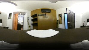 Une chambre d’hôtel avec deux lits, une porte en bois, un miroir et un téléviseur fixé au mur.