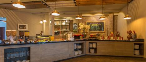 A modern kitchen with a buffet setup, including various food items and beverages.