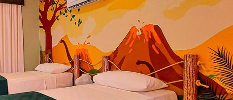 A hotel room with two beds, a mural of a volcano, and an air conditioning unit.