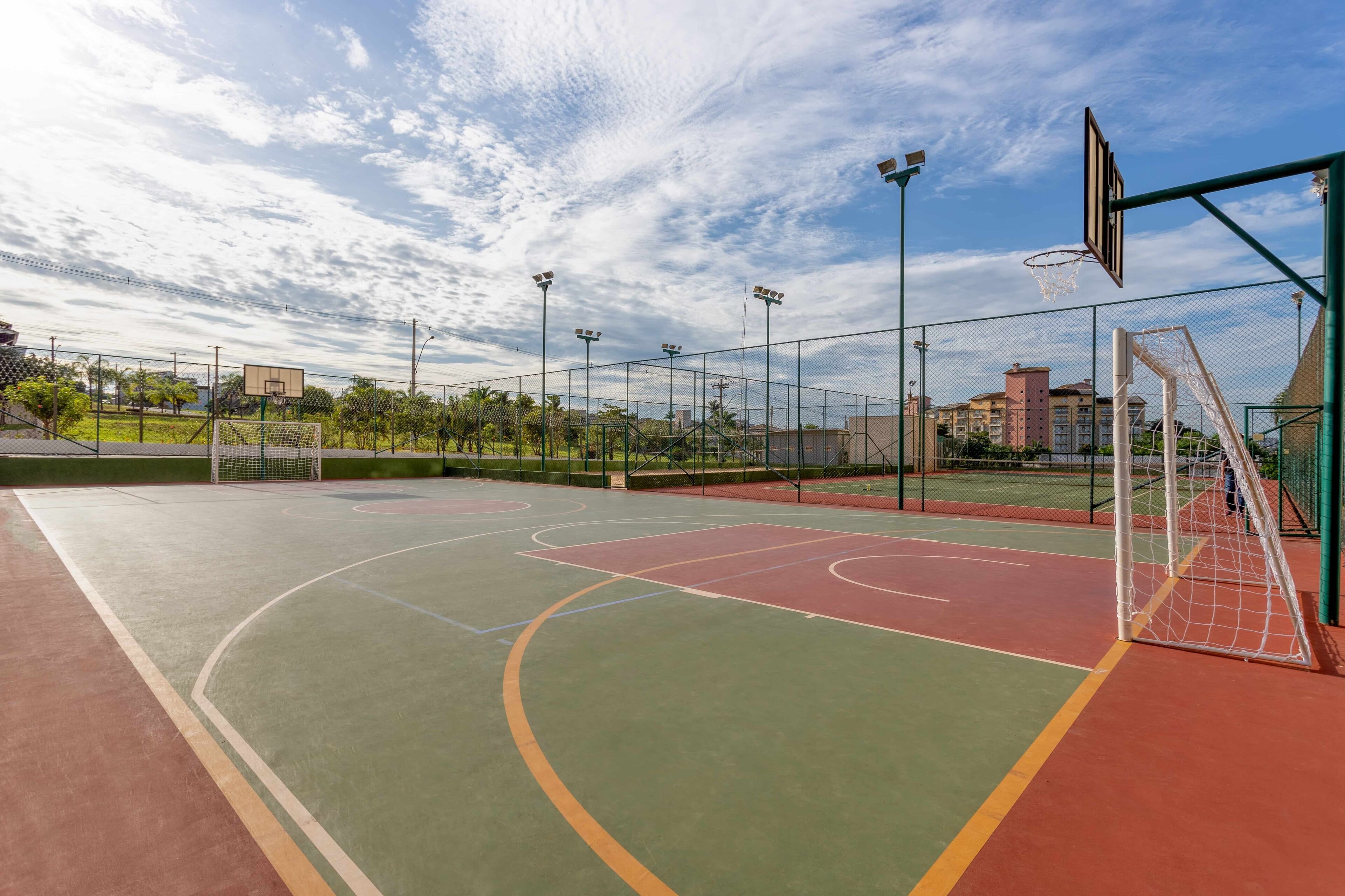 Ein Basketballplatz im Freien mit Netz, Rückwand und Beleuchtungsmasten.