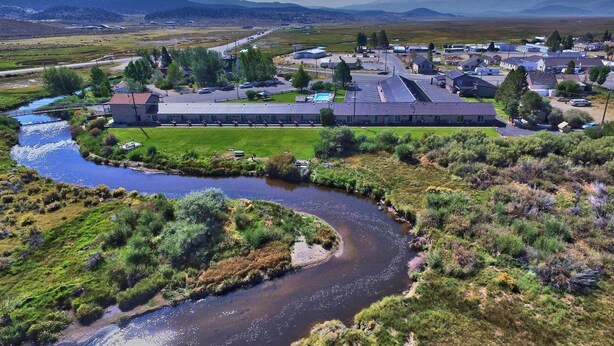 A large industrial facility with multiple buildings, a river, and surrounding greenery. - Walker River Lodge (Bridgeport)