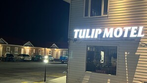 Un motel appelé « Tulip Motel », avec une enseigne, un parking et quelques voitures garées.