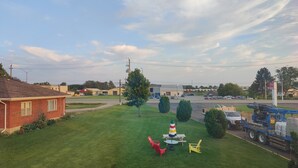 Un motel doté d’une pelouse verdoyante, de sièges extérieurs et offrant une vue sur la rue.