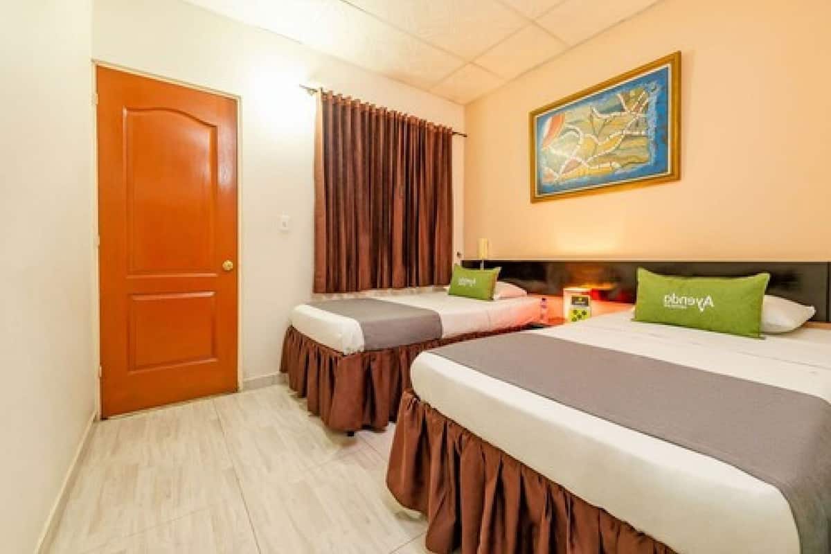 Ein Hotelzimmer mit zwei Betten, einer Holztür, einem Bild an der Wand und einem Vorhang.
