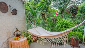 Una hamaca en un jardín exuberante con una mesa y un tocadiscos.