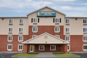 A multi-story hotel with a sign reading "Woodspring Suites." It features a brick facade, multiple windows, and a central entrance with a door. - WoodSpring Suites Virginia Beach (Virginia Beach)