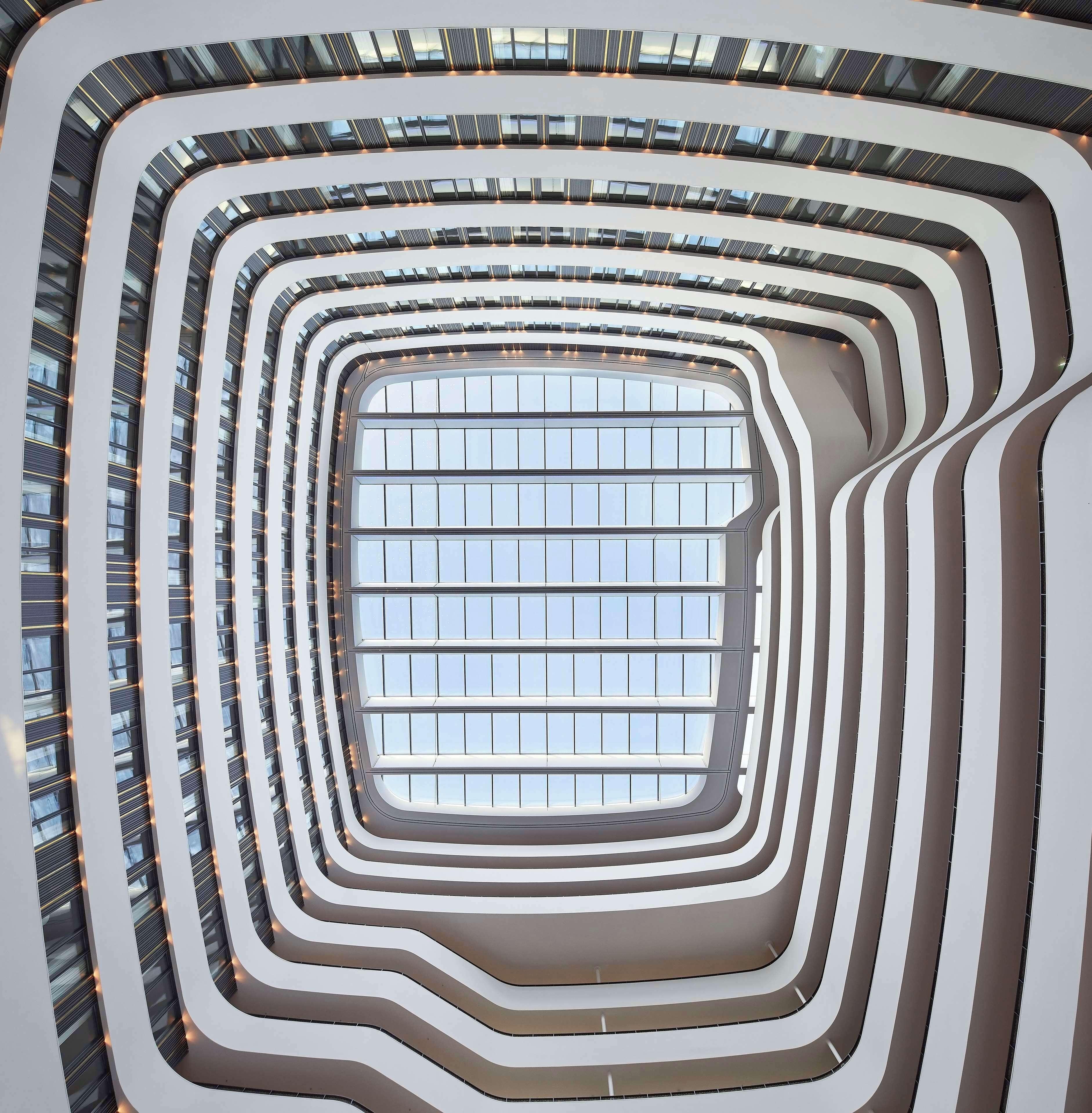 A modern building with multiple levels and a central atrium with large windows.