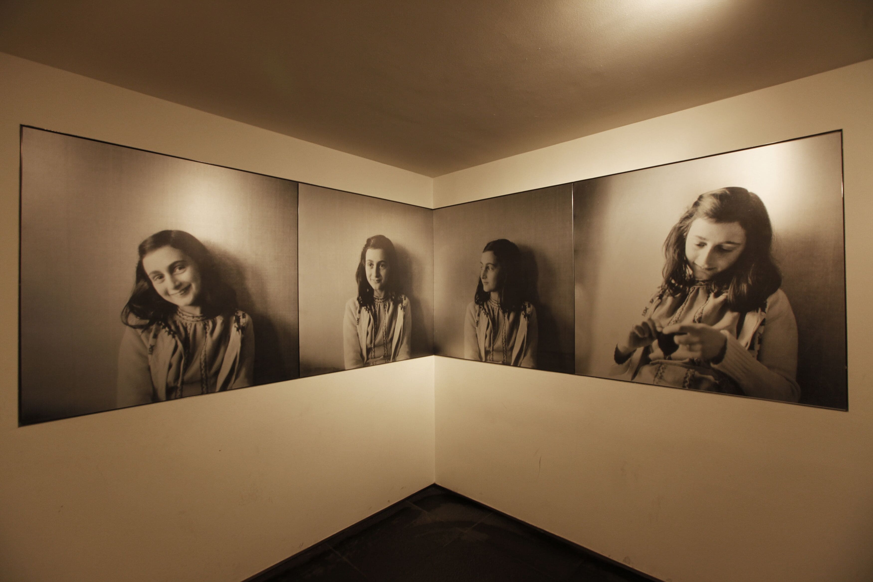 Una habitación con tres retratos enmarcados en la pared.