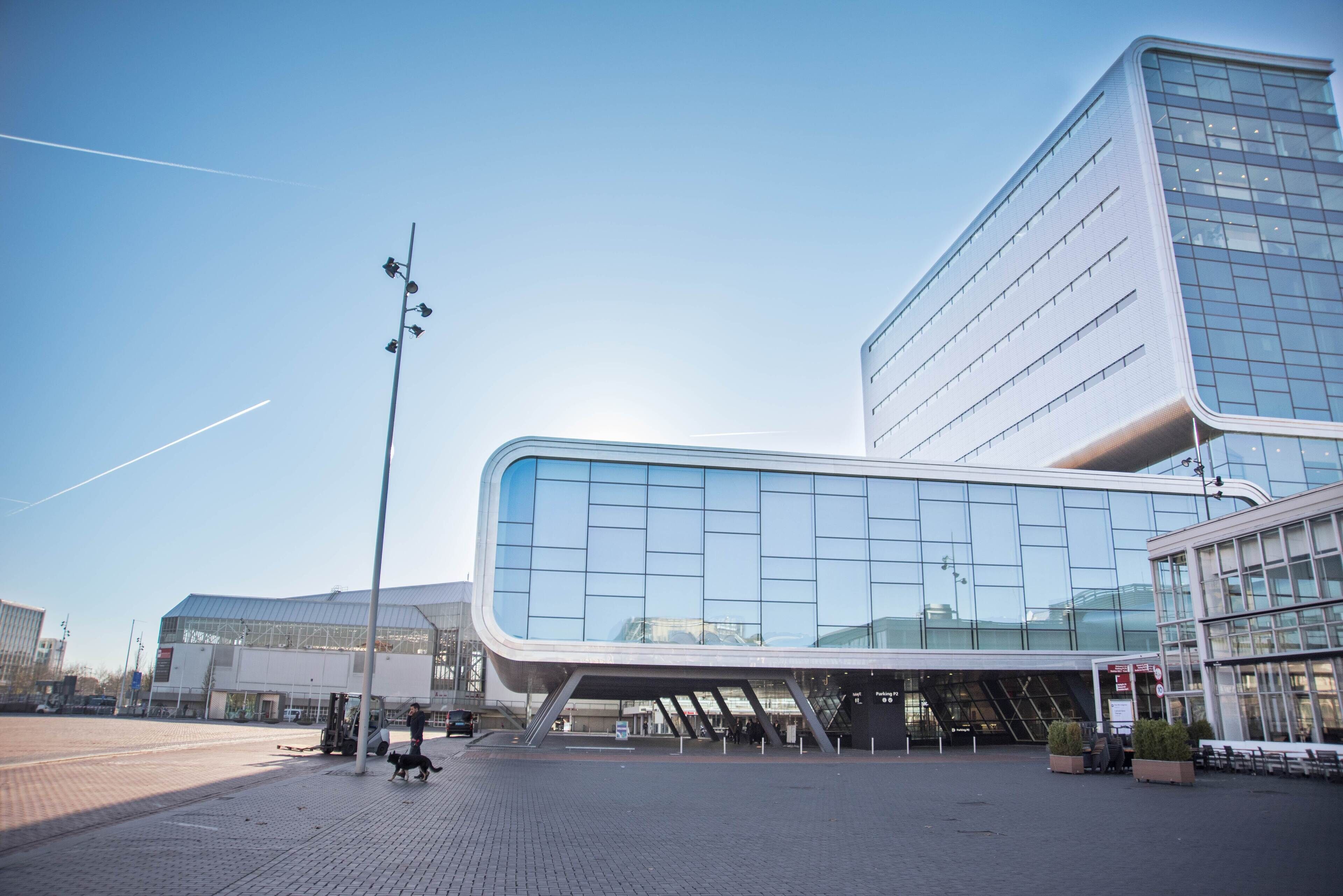 Een modern gebouw met een gebogen glazen gevel en een plat dak.