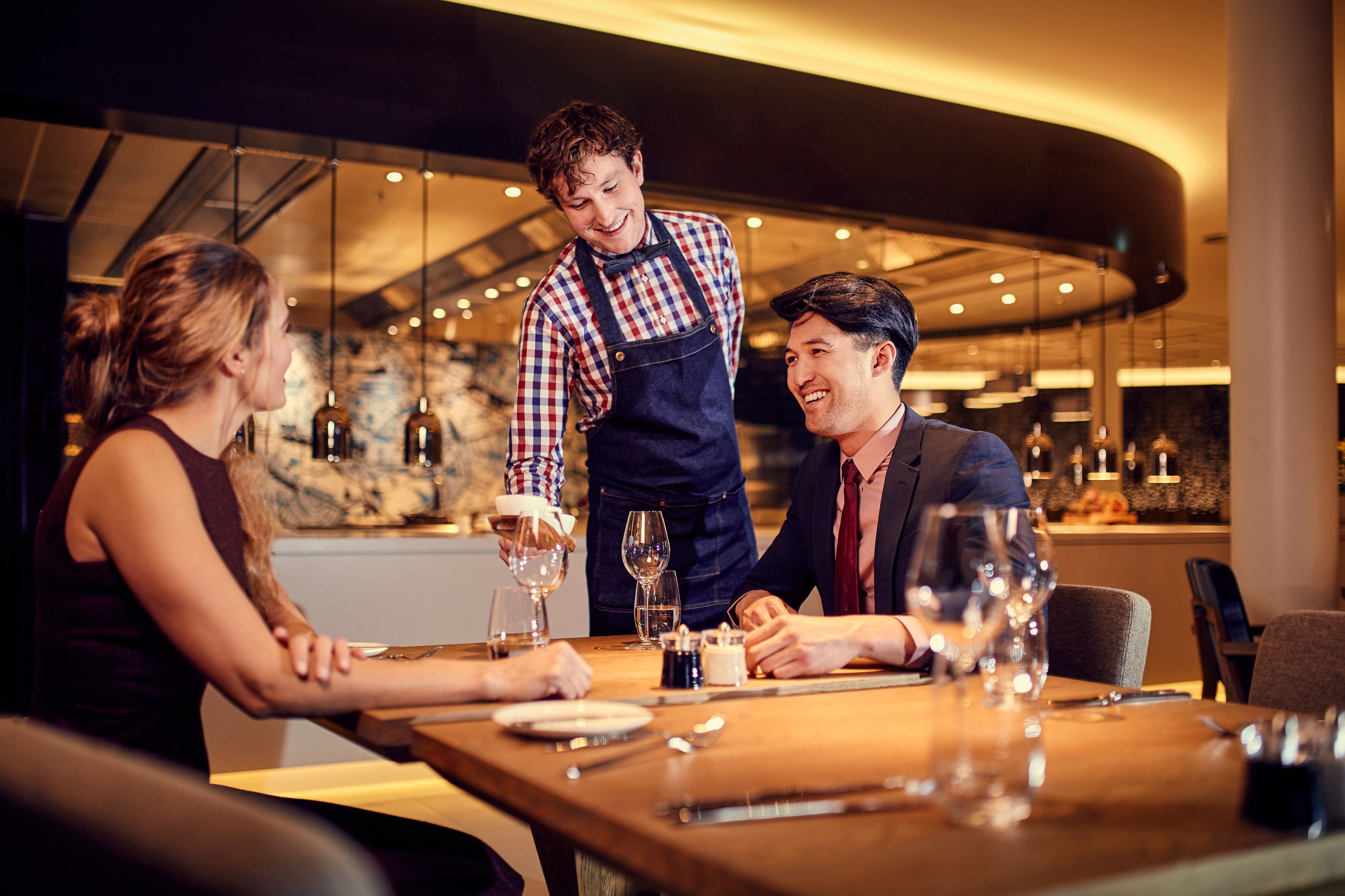 Un restaurante con un camarero atendiendo una mesa.