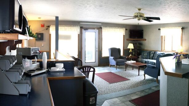 A compact living space with a kitchenette, a sofa, a dining area, and a ceiling fan. - Yorkshire Motel (York)