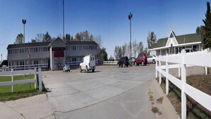 A parking lot with a white fence, a building labeled "Northeast Hotel," and several parked cars. - Yorkshire Motel (York)