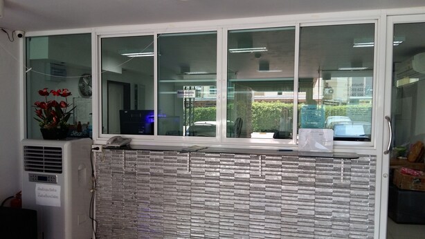 Zona de recepción con ventana, teléfono y planta en maceta.