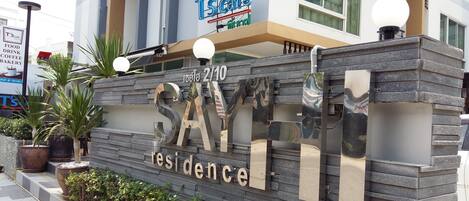 Un edificio con un letrero que dice "T's Cafe" y "Comida, Bebida, Café, Panadería".