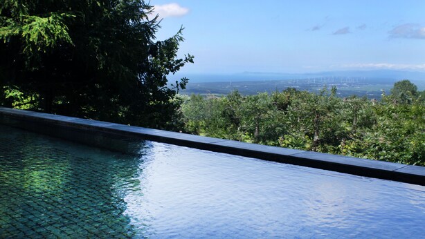 A swimming pool with a view of a cityscape and greenery.