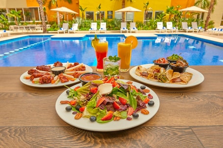 Outdoor pool, pool umbrellas, sun loungers. City Express Plus by Marriott Cabo San Lucas