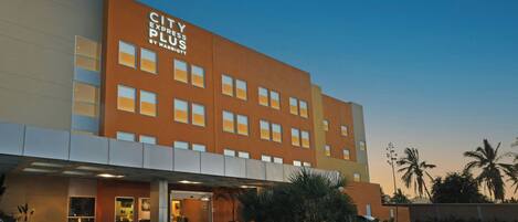 Un hotel con techo plano, múltiples ventanas y un letrero que dice 'CITY EXPRESS PLUS BY MARRIOTT'.