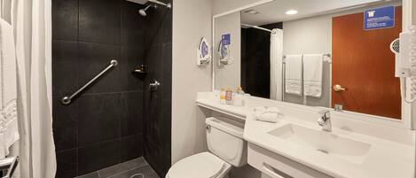 A modern bathroom with a shower, toilet, and sink.