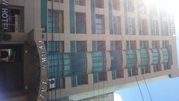 Un hotel de varios pisos con fachada moderna, con amplias ventanas y un letrero destacado del Hotel Crown View.
