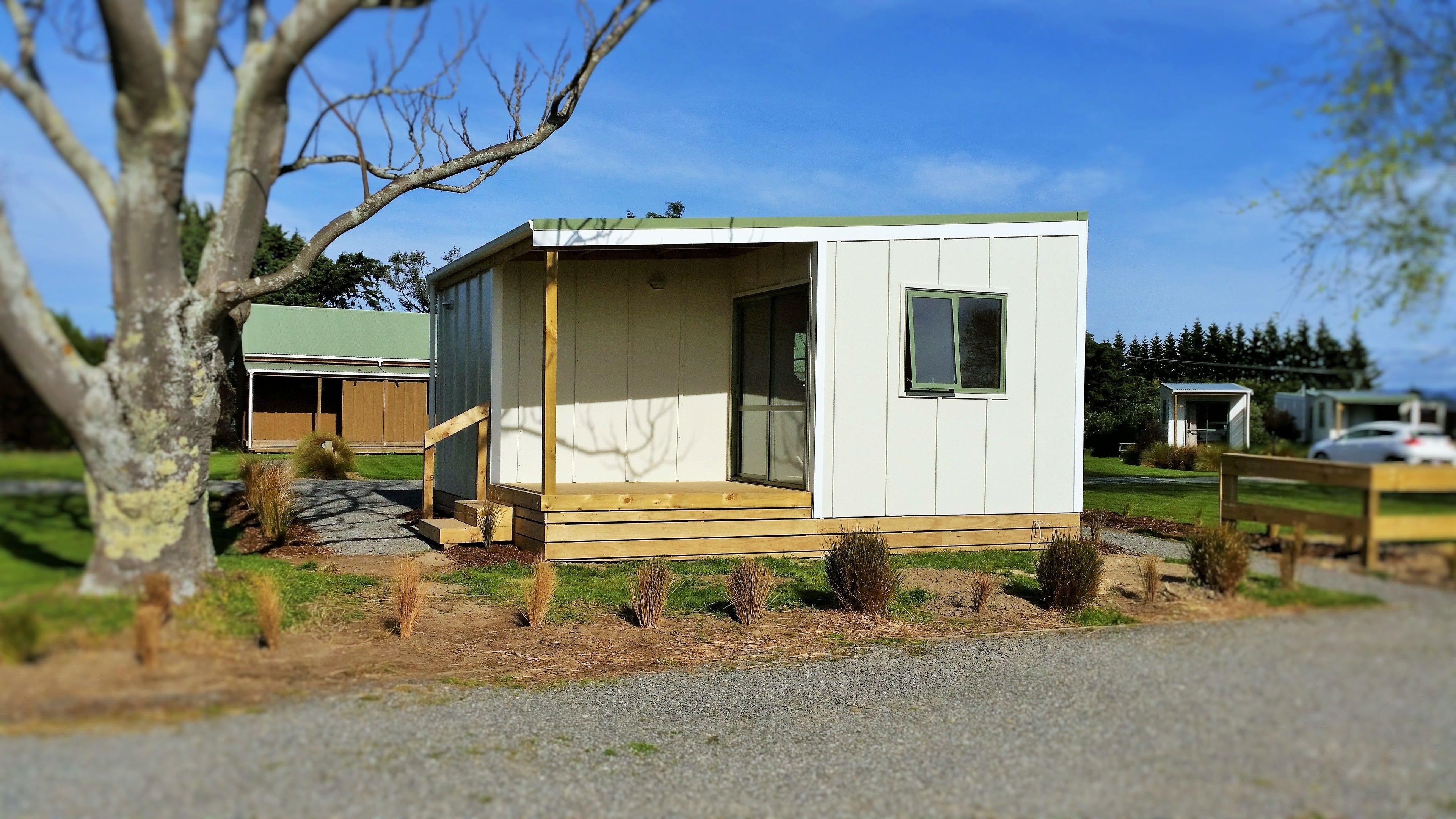 A small, single-story cabin with a wooden porch and a sliding glass door.