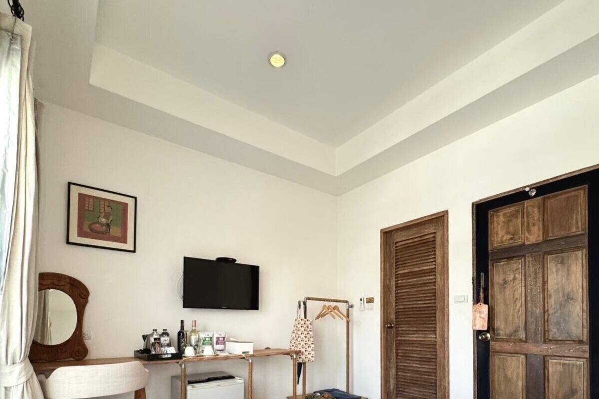 A hotel room with a bed, a desk, a television, and a wardrobe.