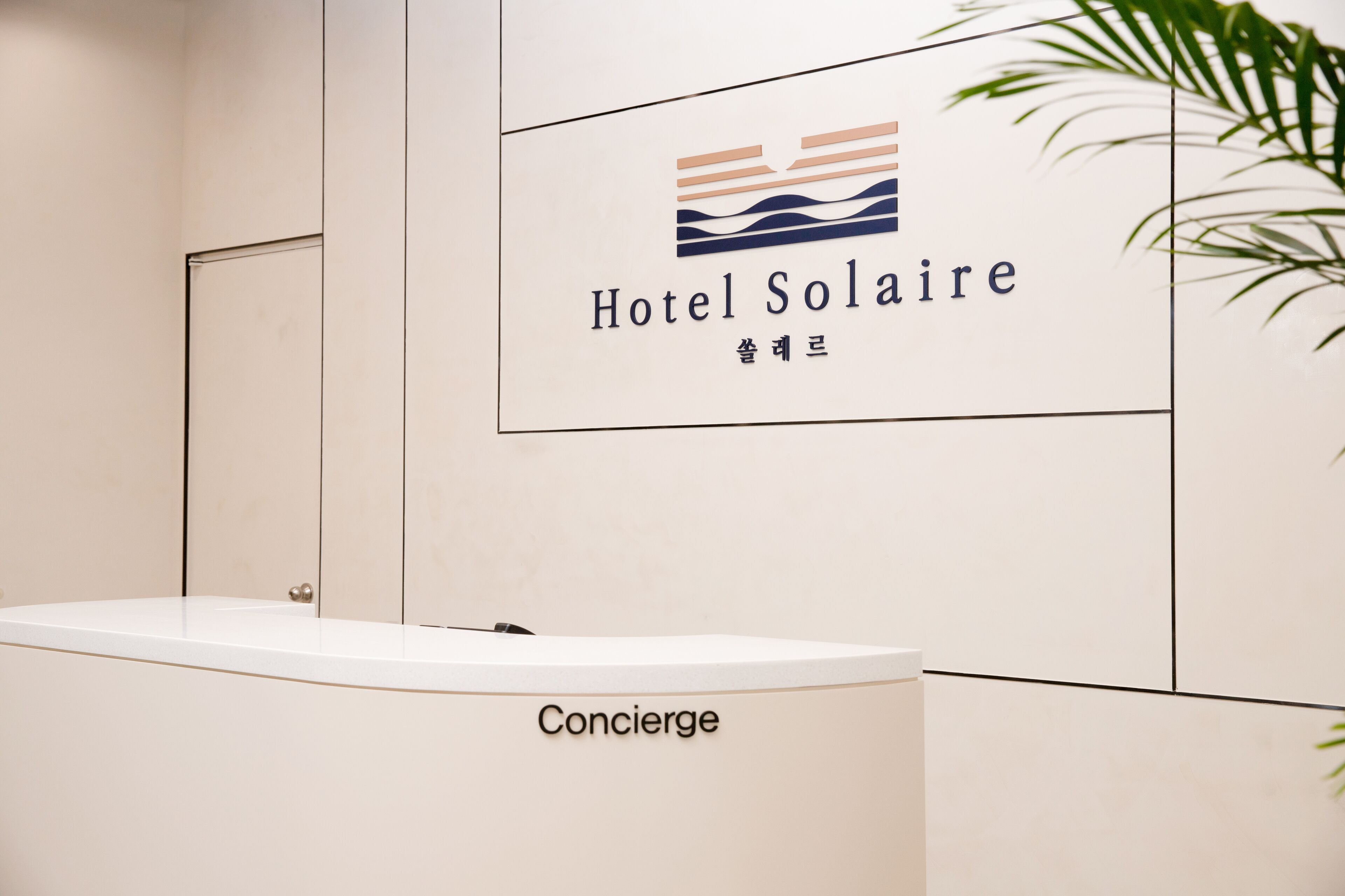 A reception desk with a logo for Hotel Soleil and a sign that reads "Concierge".