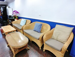 A room with wicker furniture, including a sofa set and a small table. - Xing Ji Hotel (Hengchun)
