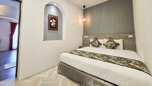 Une chambre à coucher avec un lit, un tableau accroché au mur et une porte.