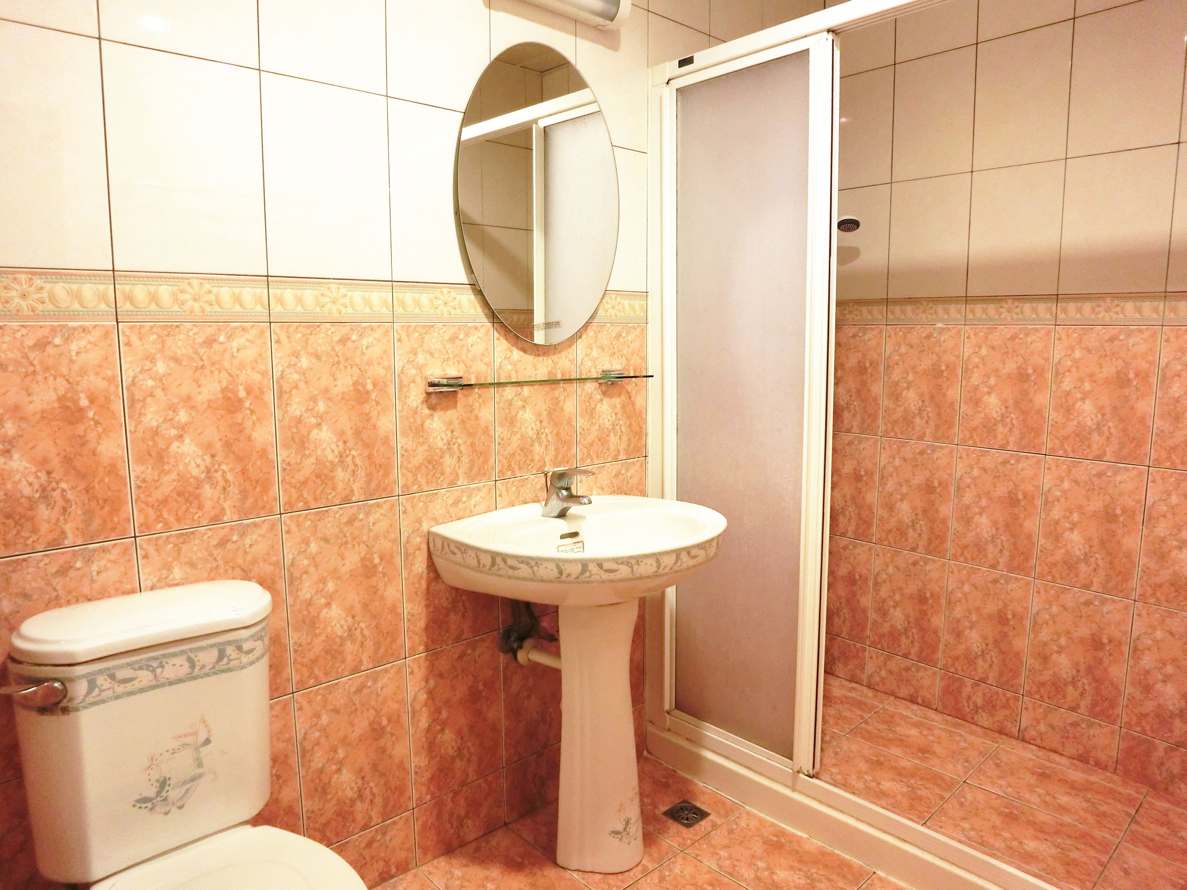 A bathroom with a toilet, sink, and shower.