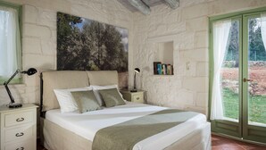 A bedroom with a bed, nightstands, a bookshelf, and a large window with curtains. - Boutique Villa Petra Amanda (Apokoronas)
