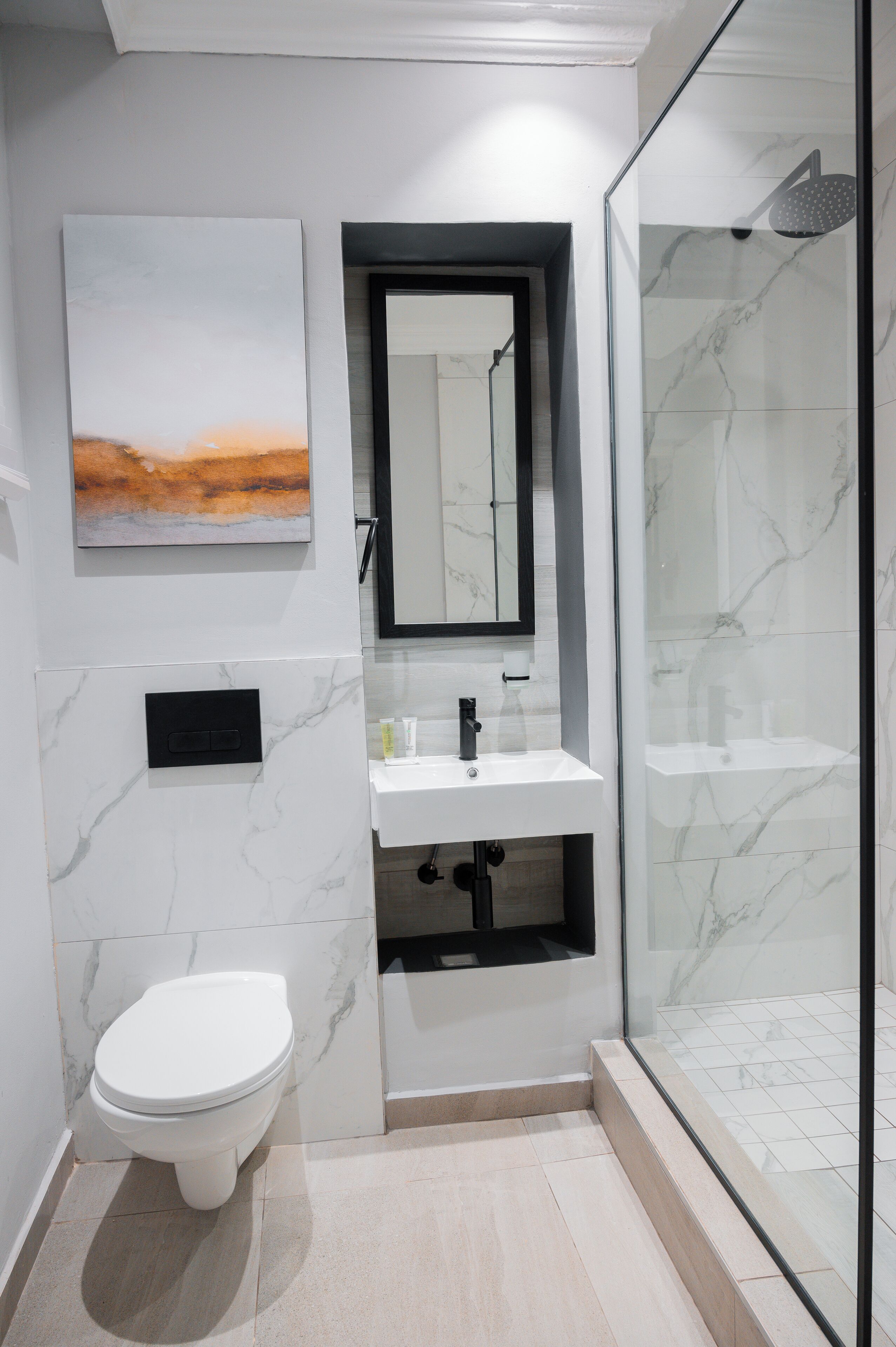 A modern bathroom with a toilet, sink, and shower.