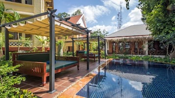 Una piscina al aire libre, tumbonas