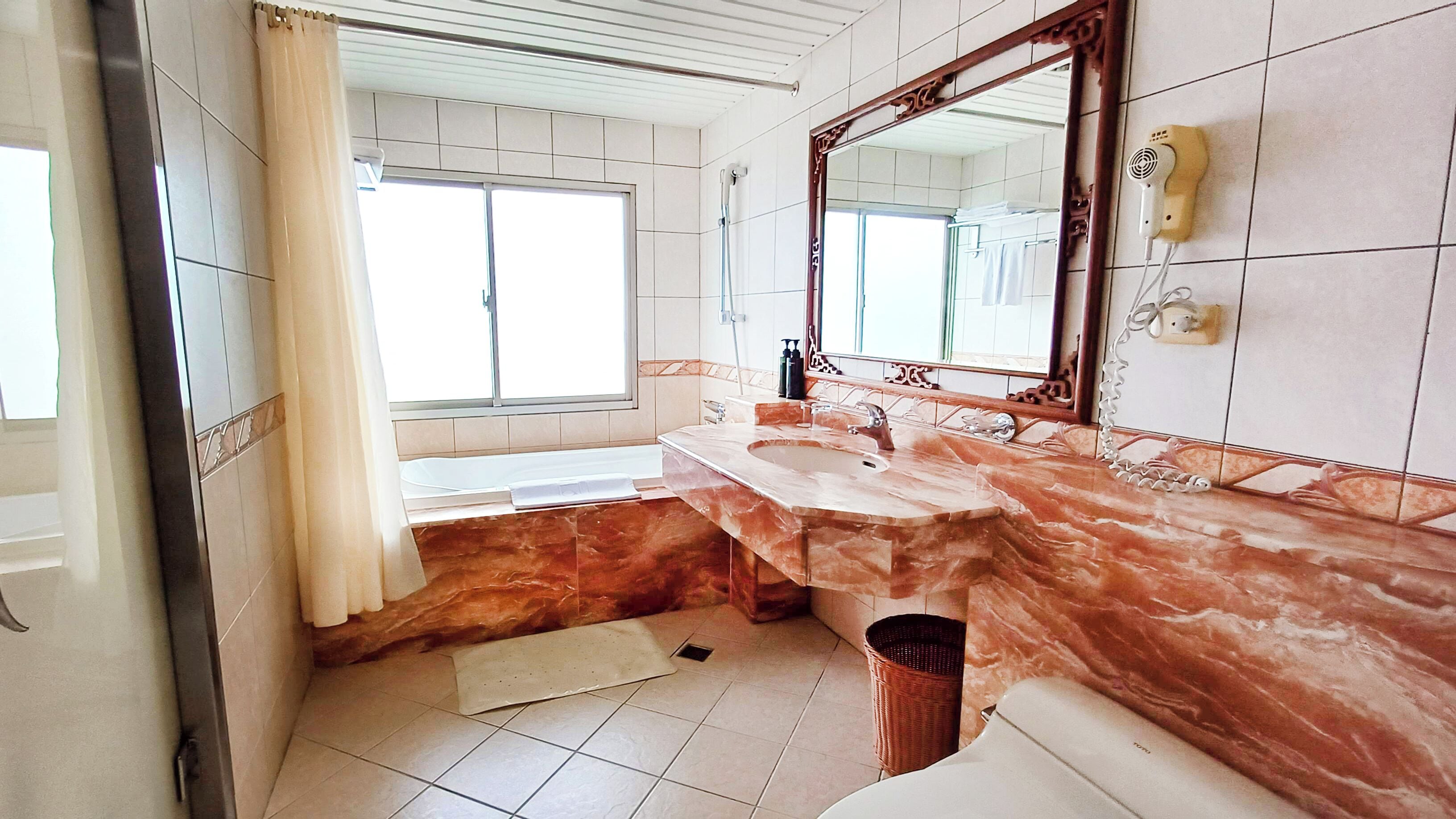 deluxe double room, 1 king bed | bathroom | free toiletries, hair dryer, slippers, towels