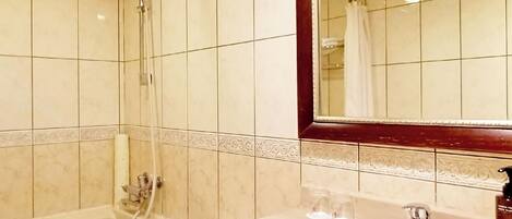 Et badeværelse med badekar, toilet og håndvask.