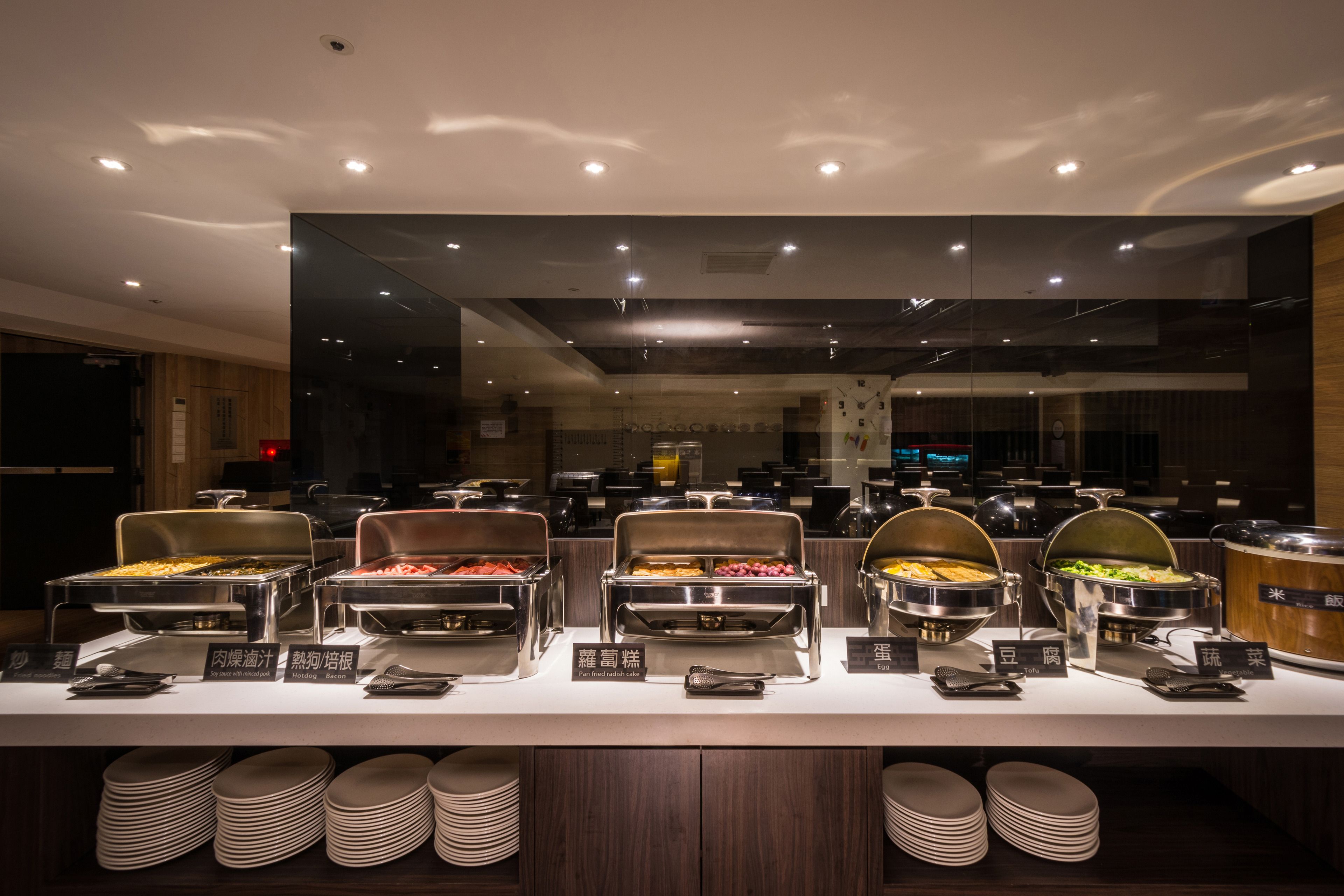 A buffet setup with multiple food stations, each labeled with Chinese characters.