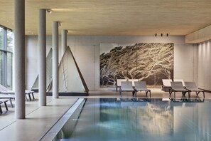 Alberca techada, alberca al aire libre y sombrillas en la alberca