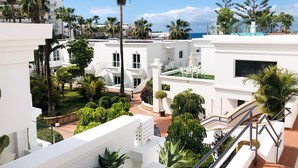 Zona residencial con edificios blancos, palmeras y cielo despejado.