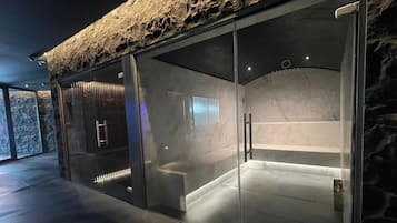 Un spa moderno con fachada de piedra, puertas de vidrio y un interior de mármol.