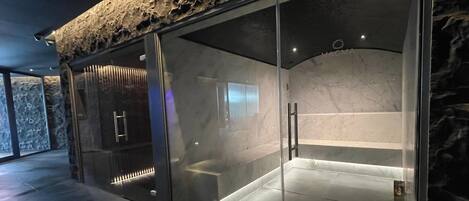 Un spa moderno con fachada de piedra, puertas de vidrio y un interior de mármol.