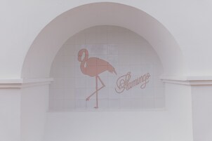 Pared blanca con un arco de azulejos. Se distingue la silueta de un flamenco y la palabra "Flamingo".