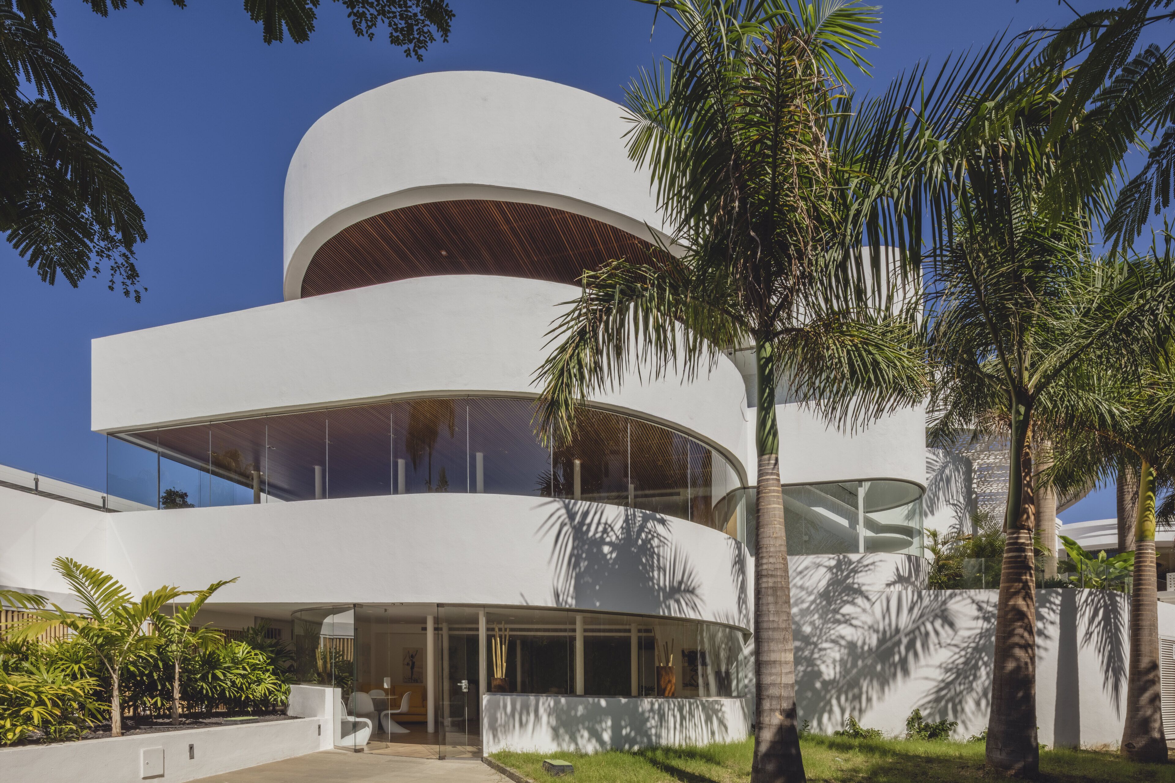 A modern multi-story building with large windows and a curved facade.