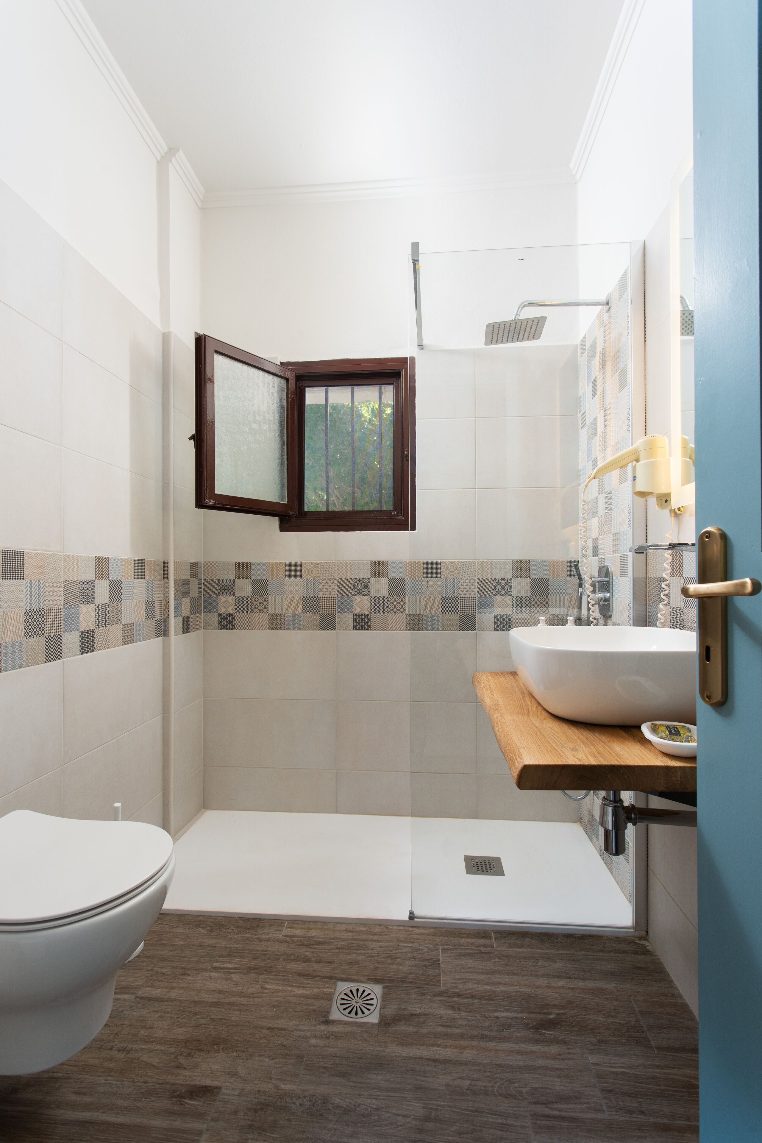A bathroom with a toilet, shower, and sink.
