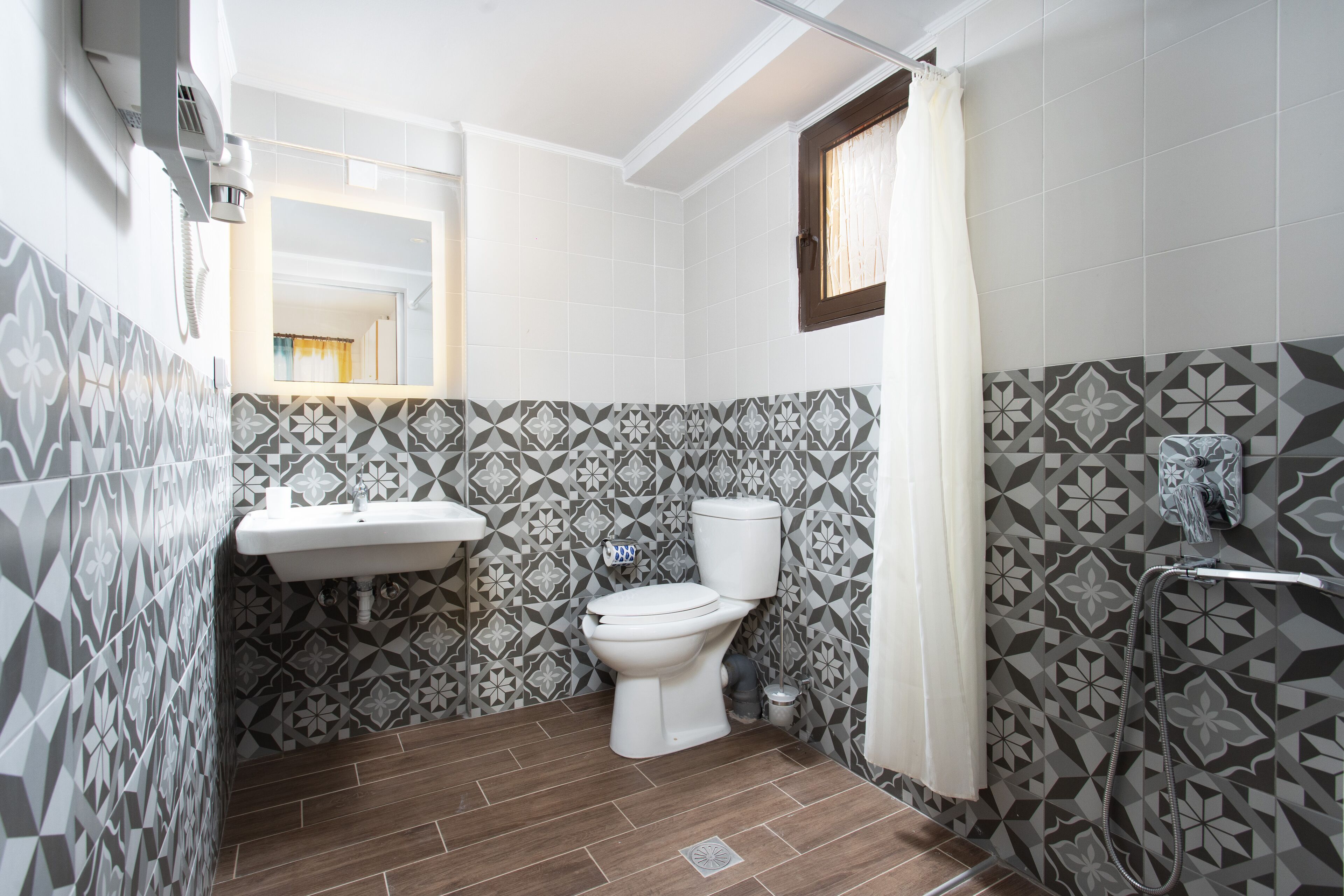 Un baño con inodoro, lavabo y ducha.