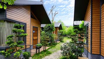 Un edificio moderno con revestimiento de madera y un sendero de ladrillo que conduce a una terraza de madera.