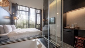 A modern hotel room with a large bed, a glass shower enclosure, a small kitchenette, and a view of the outdoors. - Pokara Resort (Jiaoxi)