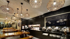 A restaurant with wooden benches and hanging decorative light fixtures. - Pokara Resort (Jiaoxi)