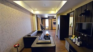 Una sala de estar moderna con un sofá, una mesa de centro, un televisor y una pequeña zona de bar.