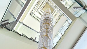 Un interior moderno con una escalera de cristal y una lámpara decorativa.