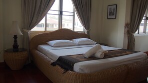 A room with a wicker bed, a lamp, and a view through the window. - Lalco AR Hotel (Vientiane)