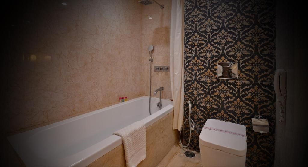 A bathroom with a bathtub, toilet, and shower.